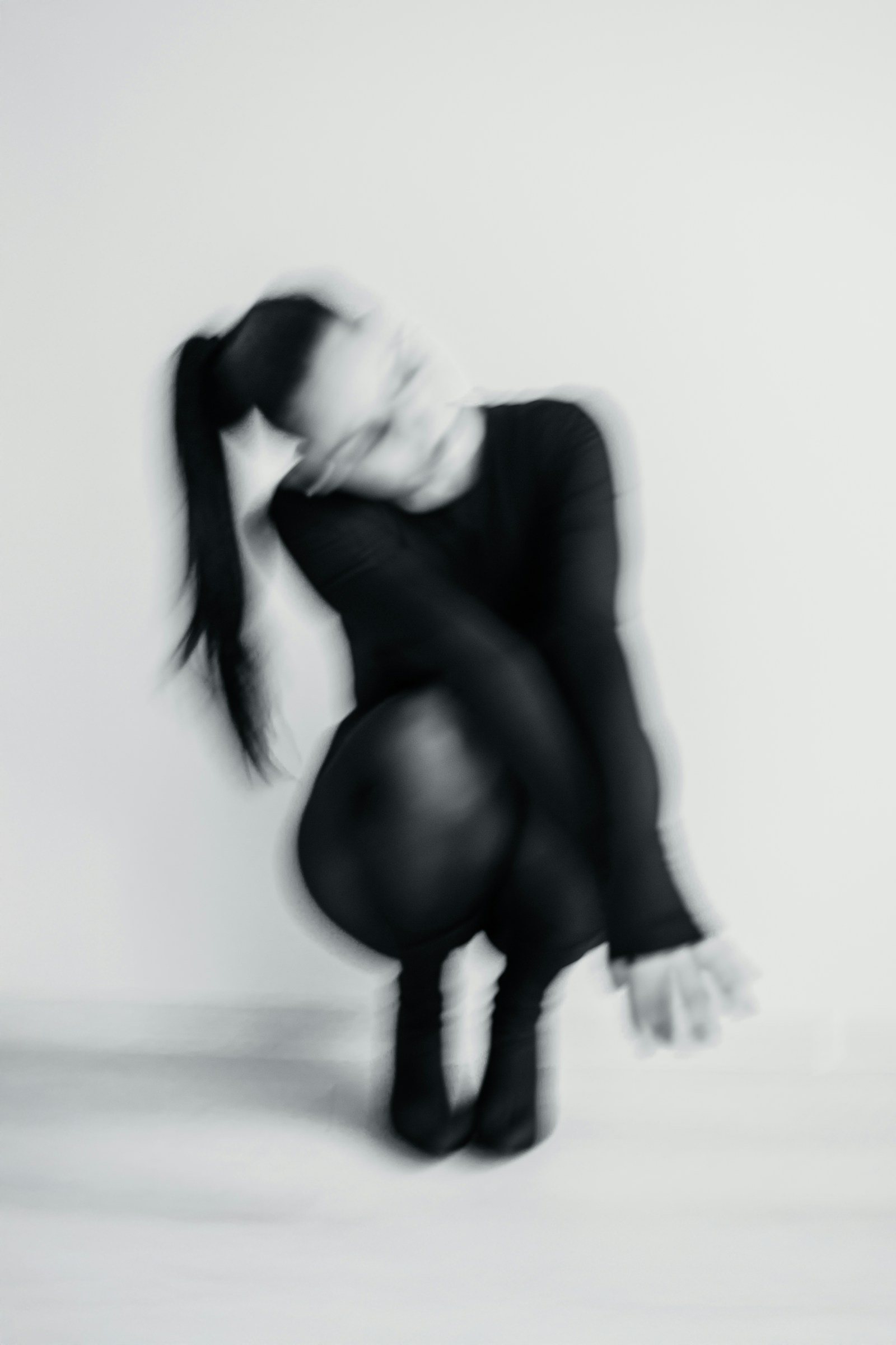 A dancer photographed in a studio, holding a quiet moment of movement