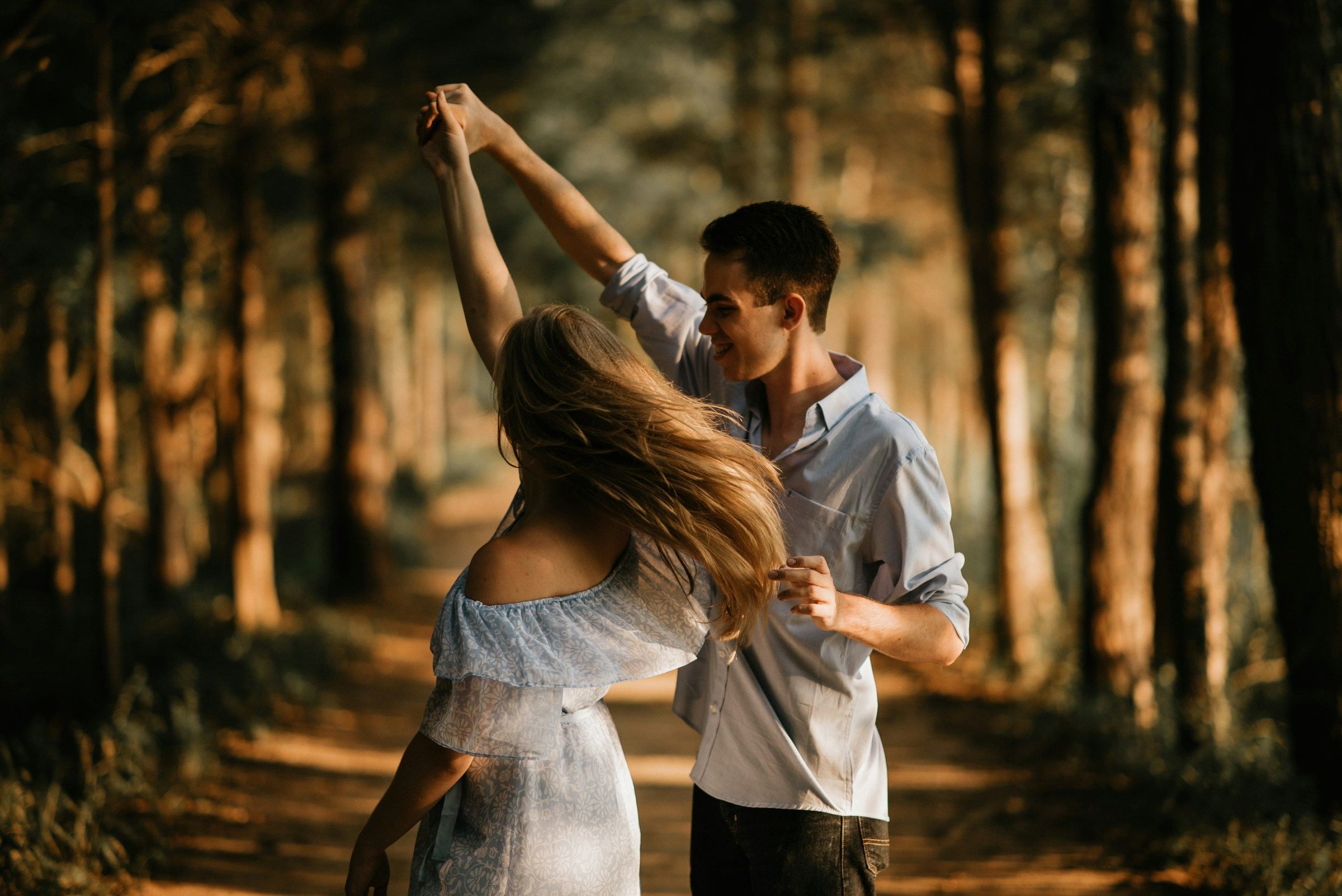 A couple dancing outdoors among trees