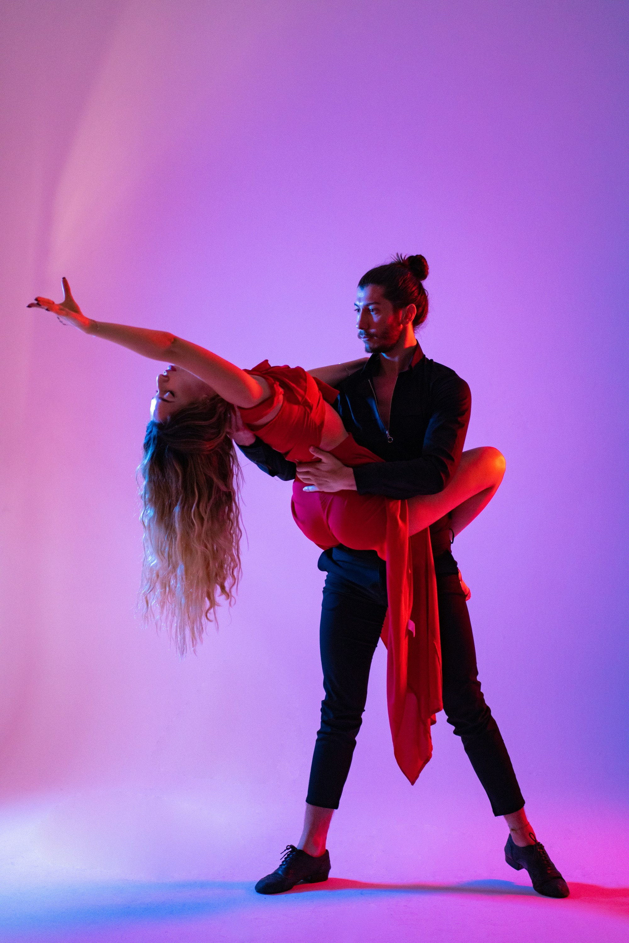 Two dancers in a close partner hold, photographed in warm light